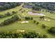 Aerial view of a golf course with a winding creek and a clubhouse in a wooded community at 6455 Darely Ct, Cumming, GA 30040