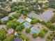 Aerial view featuring tennis courts, swimming pool, ponds, and residential homes in a community at 6455 Darely Ct, Cumming, GA 30040