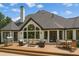 An outdoor dining and lounge area with stone chimney and a well-maintained backyard at 6455 Darely Ct, Cumming, GA 30040
