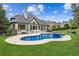 A beautiful backyard with a kidney-shaped pool, spa, large windows, and lush greenery at 6455 Darely Ct, Cumming, GA 30040