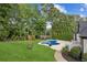 Gorgeous backyard with a kidney-shaped pool, spa, lush greenery, and a sun-lounging patio at 6455 Darely Ct, Cumming, GA 30040