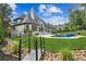 An expansive backyard showcases a kidney-shaped pool, spa, lush greenery, and a charming bridge at 6455 Darely Ct, Cumming, GA 30040