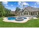 A stunning backyard with a kidney-shaped pool, spa, patio, lush greenery, and beautiful landscaping at 6455 Darely Ct, Cumming, GA 30040