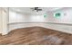 Finished basement with decorative chair rails, two windows, a ceiling fan, and wood flooring at 6455 Darely Ct, Cumming, GA 30040