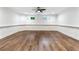 Finished basement has decorative chair rails, two windows, a ceiling fan, and wood floors at 6455 Darely Ct, Cumming, GA 30040