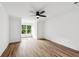 Bright bedroom with a ceiling fan and a large window overlooking a wooded backyard at 6455 Darely Ct, Cumming, GA 30040
