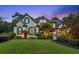 Charming two-story home with a well-manicured lawn and beautiful landscaping at twilight at 6455 Darely Ct, Cumming, GA 30040