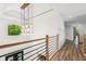 Bright hallway featuring wood floors, modern railing, and stunning chandelier lighting at 6455 Darely Ct, Cumming, GA 30040