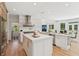 Spacious kitchen with island, breakfast bar, white cabinetry, and an adjoining dining area at 6455 Darely Ct, Cumming, GA 30040