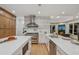 A bright and airy kitchen featuring a stainless steel range hood, double islands, and hardwood floors at 6455 Darely Ct, Cumming, GA 30040