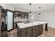 Stylish kitchen with a marble countertop island, dark wood cabinets, and stainless steel refrigerator at 6455 Darely Ct, Cumming, GA 30040