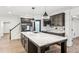 This kitchen has a large kitchen island with marble countertop and dark wood cabinets at 6455 Darely Ct, Cumming, GA 30040