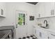 Well-lit laundry room features modern appliances, cabinetry, and checkerboard flooring at 6455 Darely Ct, Cumming, GA 30040