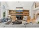 Comfortable living area with fireplace, modern shelving, and a staircase leading to the upper floor at 6455 Darely Ct, Cumming, GA 30040
