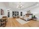 Spacious main bedroom with a large bed, tray ceiling, chandelier, sitting area and hardwood floors at 6455 Darely Ct, Cumming, GA 30040