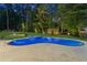 Inviting pool with surrounding mature trees and manicured lawn in backyard at 6455 Darely Ct, Cumming, GA 30040