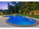 Inviting pool with surrounding mature trees and manicured lawn in backyard at 6455 Darely Ct, Cumming, GA 30040