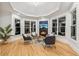 Cozy sitting area with a fireplace, large windows, and stylish chairs with a modern rug on hardwood floor at 6455 Darely Ct, Cumming, GA 30040
