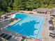 Large swimming pool with lounge chairs, tables, umbrellas, and manicured landscaping at 6455 Darely Ct, Cumming, GA 30040