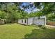 Spacious backyard featuring a grassy area, a small patio area, privacy fence, and lush green trees at 1477 Spruce Dr, Smyrna, GA 30080