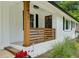 Charming front porch with white brick, stylish wood railing, and a welcoming front door at 1477 Spruce Dr, Smyrna, GA 30080