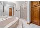 Bright bathroom features a soaking tub, glass-enclosed shower, and wood cabinets for ample storage at 786 Mitsy Pt, Marietta, GA 30068