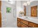 Bathroom with wood vanity, white tile flooring, and shower, showcasing a functional and bright space at 786 Mitsy Pt, Marietta, GA 30068