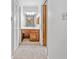Hallway view into a bathroom featuring white fixtures, a wood vanity, and plenty of light from an exterior window at 786 Mitsy Pt, Marietta, GA 30068