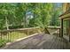 Spacious wooden deck with railings overlooks a lush, green backyard with mature trees, perfect for outdoor entertaining at 786 Mitsy Pt, Marietta, GA 30068