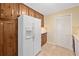 Kitchen view showcasing the pantry, refrigerator, and wooden cabinets with light tile flooring at 786 Mitsy Pt, Marietta, GA 30068