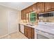 Traditional kitchen featuring wood cabinets, tile backsplash, white appliances, and a bright window view at 786 Mitsy Pt, Marietta, GA 30068