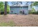 Home exterior with sliding glass doors leading to a patio, complemented by a tree-lined backyard at 9025 Huntwood Ln, Riverdale, GA 30274