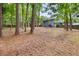 Expansive backyard with mature trees and a view of the home's exterior, offering ample space at 9025 Huntwood Ln, Riverdale, GA 30274