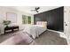 Bedroom featuring large window, modern decor, and accent wall at 9025 Huntwood Ln, Riverdale, GA 30274
