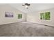 Expansive carpeted bedroom featuring forest views, a ceiling fan, and neutral decor at 9025 Huntwood Ln, Riverdale, GA 30274