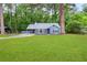Captivating curb appeal with fresh green lawn surrounding the delightful, light blue home in a wooded area at 9025 Huntwood Ln, Riverdale, GA 30274