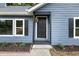 Welcoming front entryway featuring a modern black door, framed by stylish black accents and garden bed at 9025 Huntwood Ln, Riverdale, GA 30274