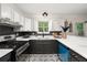 Galley kitchen featuring modern gas range, cabinetry, and stone countertops at 9025 Huntwood Ln, Riverdale, GA 30274