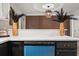 Island with black cabinets and blue dishwasher in remodeled kitchen with white countertops and accent wall at 9025 Huntwood Ln, Riverdale, GA 30274