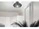 Close up of a modern light fixture with a black woven pattern in a remodeled kitchen with white cabinets at 9025 Huntwood Ln, Riverdale, GA 30274