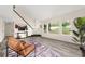 Sun-drenched living room with comfortable seating, a modern staircase, and large windows offering scenic views at 9025 Huntwood Ln, Riverdale, GA 30274