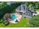 Aerial view of a large home and in-ground pool with stone patio, waterfall, hot tub, and water slide at 2871 Hosch Valley Rd, Buford, GA 30519