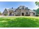 Stunning stone home with arched entryway and manicured lawn exudes curb appeal and timeless elegance at 2871 Hosch Valley Rd, Buford, GA 30519
