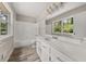 Bright bathroom with wood floors, white vanity, and natural light at 5058 Rock Springs Rd, Lithonia, GA 30038