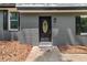 Close-up of the front door with decorative window, set in a gray brick facade at 5058 Rock Springs Rd, Lithonia, GA 30038