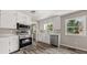 Well-lit kitchen with stainless steel appliances, white cabinetry, and wood-look floors, offering a modern design at 5058 Rock Springs Rd, Lithonia, GA 30038