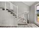 Carpeted staircase with white railing, flooded with natural light and offering a glimpse of the front door at 5058 Rock Springs Rd, Lithonia, GA 30038