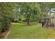 Lush backyard with mature trees, green lawn, wooden fence, and wrought iron table at 1363 Sylvan Ne Cir, Brookhaven, GA 30319