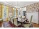 Elegant dining room featuring floral wallpaper, hardwood floors, wainscoting, and a stylish chandelier at 1363 Sylvan Ne Cir, Brookhaven, GA 30319