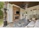 Outdoor living space with a stone fireplace, seating area, ceiling fan, and stone flooring at 1363 Sylvan Ne Cir, Brookhaven, GA 30319
